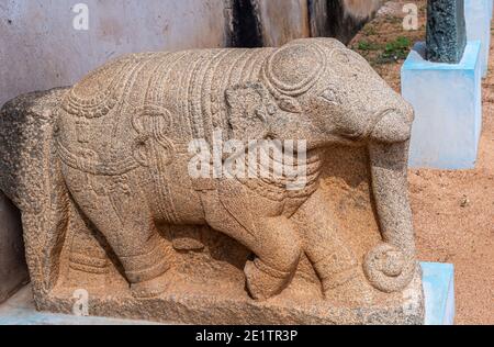 Hampi, Karnataka, Indien - 5. November 2013: Zanana Enclosure. Graue Stein Elefant Statue auf blauem Sockel. Stockfoto
