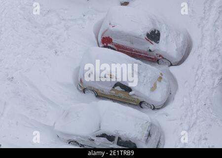 Madrid, Spanien - 09. Januar 2021: Autos geparkt, blockiert und komplett von Schnee und Eis begraben, an einem verschneiten Tag, aufgrund der Filomena polare Kaltfront. Stockfoto