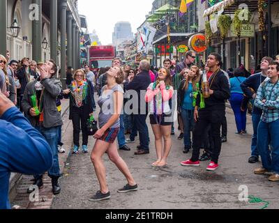 NEW ORLEANS, LA - 9. FEBRUAR 2013: Verschiedene Menschenmassen, die während des Karnevals auf dem Balkon der Bourbon Street Perlen erbitten Stockfoto