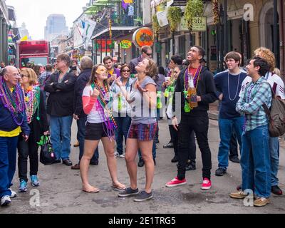 NEW ORLEANS, LA - 9. FEBRUAR 2013: Menschenmenge, die während des Karnevals auf der Bourbon Street um Perlen bettelt Stockfoto