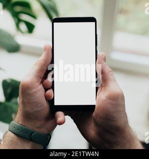 Mann hält Smartphone mit weißem Bildschirm Stockfoto