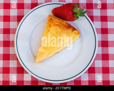Ananasscheibe auf dem Kopf mit Glacé Straberry isoliert auf italienischer rot-weiß karierter Tischdecke.Draufsicht. Hausgemachtes Backen. Stockfoto