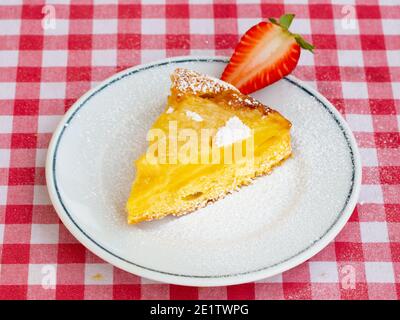 Ananasscheibe auf dem Kopf mit Glacé Straberry isoliert auf italienischer rot-weiß karierter Tischdecke.Draufsicht. Hausgemachtes Backen. Stockfoto