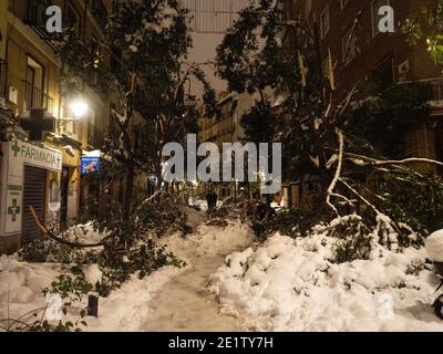 Madrid, Spanien. Januar 2021. Blick auf eine Straße in der Nacht mit Ästen von umgestürzten Bäumen durch den Schneefall des Sturms Filomena bedeckt. Sturm Filomena trifft Madrid (Spanien), ein Wetteralarm wurde für kalte Temperaturen und schwere Schneestürme in ganz Spanien ausgegeben; nach Angaben der Wetteragentur Aemet wird voraussichtlich einer der schneesichersten Tage der letzten Jahre sein. © Valentin Sama-Rojo/Alamy Live News. Stockfoto