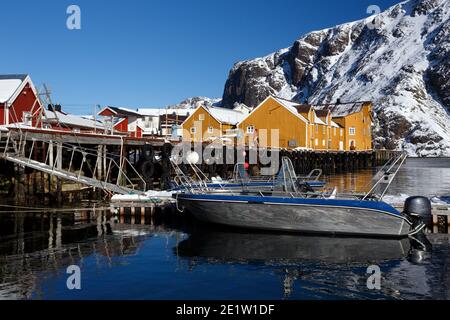 Nusfjord und traditionelle norwegische Holzhaus Rorbu auf dem Ufer des Fjords mit Bergen in der Ferne stehen. Lofoten-Inseln. Norwegen. Stockfoto