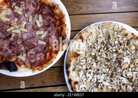 Blick von oben auf Schinken und Ananas sowie Pilze und Zwiebeln Pizza Stockfoto