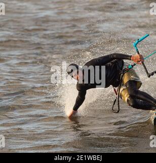 Kite Surfer gleitet auf einer sehr hohen Geschwindigkeit und berührt das Wasser. Selektiver Fokus, Kopierbereich für Text, Sportfoto. Stockfoto