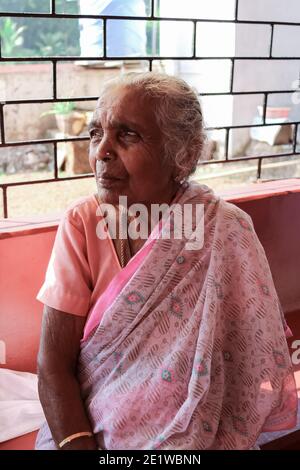Alte schöne indische Frau Oma in einem Sari auf der Bank sitzen. Stockfoto