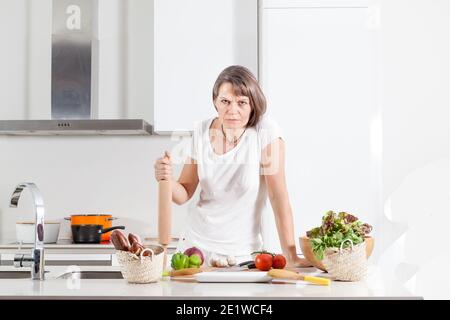 europäische mürrische Frau mittleren Alters in der Küche Stockfoto