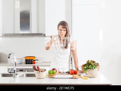 europäische mürrische Frau mittleren Alters in der Küche Stockfoto