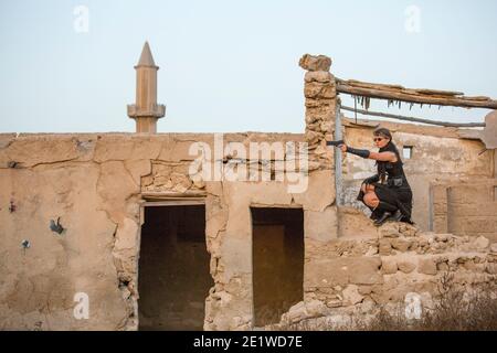 Frau mittleren Alters trägt Steampunk Kostüm der Freiheit Kämpfer in Ihr altes zerstörtes Dorf Stockfoto