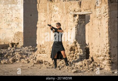 Frau mittleren Alters trägt Steampunk Kostüm der Freiheit Kämpfer in Ihr altes zerstörtes Dorf Stockfoto