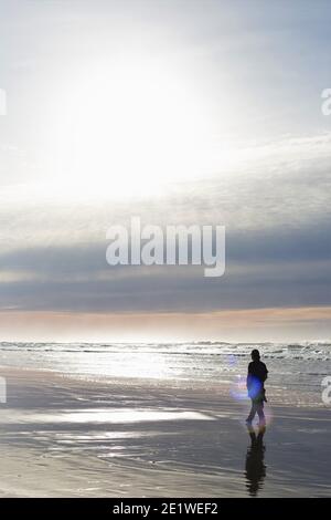 Silhouette eines Mannes allein am Strand. Stockfoto