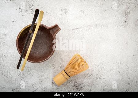 Matcha Set Bambus Matcha Schneebesen und Chashaku Tee Schaufel, Matcha Keramik Schüssel auf weißem Beton Hintergrund. Stockfoto