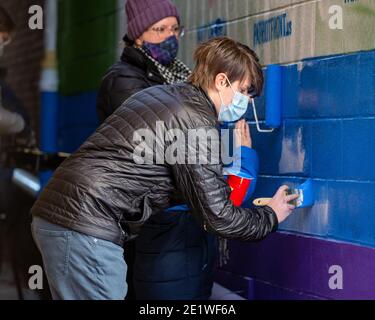 Al Eburne von Bellefonte hilft, ein Wandbild zu übermalen, das mit weißen nationalistischen Graffiti verwüstet wurde.Dutzende von Community-Mitgliedern versammelten sich bei Jake's Cards and Games, um das defaced Pride-Wandbild auf der Seite des Unternehmens neu zu malen. Freiwillige wechselten sich ab, um die sprühgemalten Botschaften der weißen nationalistischen Gruppe Patriot Front zu übermalen. Stockfoto