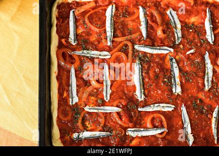 Frisch gebackene hausgemachte Fischpastete mit Basilikum und salziger Fisch-Sardine Bei hölzernen Schneidebrett Mittelmeer Meernahrung Stockfoto