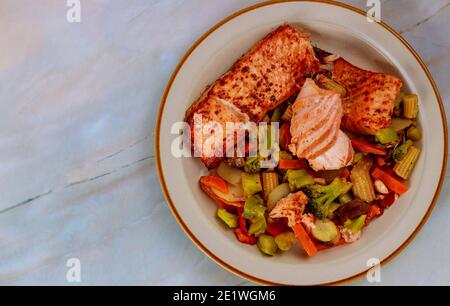 Gedünsteter Lachs und Gemüse auf dem Teller. Draufsicht. Speicherplatz kopieren. Stockfoto