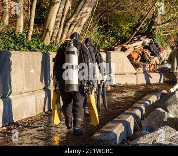 Taucher, die an der Küste spazieren gehen, um im Meer in North Vancouver BC/Kanada zu tauchen - November 8,2020. Selektiver Fokus, Reisefoto, Straßenansicht. Stockfoto