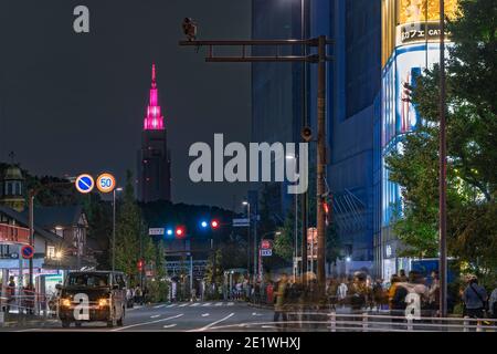 tokio, japan - 05 2019. november: Nachtansicht des Fußgängerübergangs vor dem Bahnhof Harajuku mit dem beleuchteten Turm von NTT Docomo Stockfoto