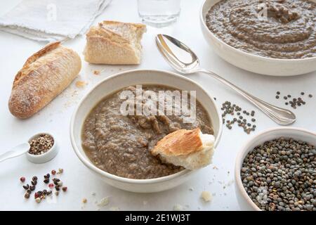 Nahaufnahme auf einem Teller Suppe oder Linsenpüree mit Brot und einen Löffel Stockfoto