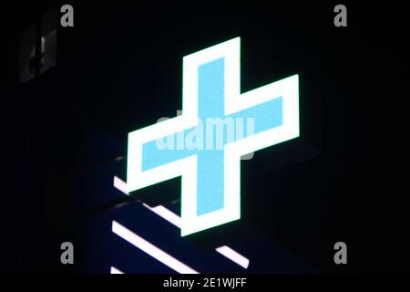 Leuchtendes Pixelkreuz von LED-Lampen auf schwarzem Hintergrund. Weißes Kreuz mit blauem Zentrum Symbol für Gesundheit, Medizin, Selbstversorgung. Stock Foto mit leerem Raum Stockfoto