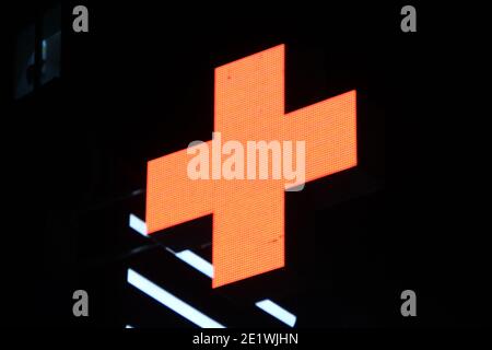 Leuchtendes Pixelkreuz von LED-Lampen auf schwarzem Hintergrund. Orange Kreuz Symbol für Gesundheit, Medizin, Selbstversorgung. Stock Foto mit leerem Platz für Text und de Stockfoto