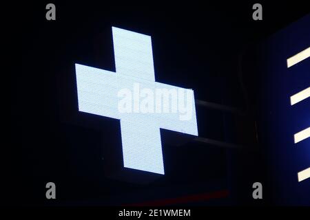 Leuchtendes Pixelkreuz von LED-Lampen auf schwarzem Hintergrund. Blaues Kreuz Symbol für Gesundheit, Medizin, Selbstversorgung. Stock Foto mit leerem Platz für Text und Desi Stockfoto