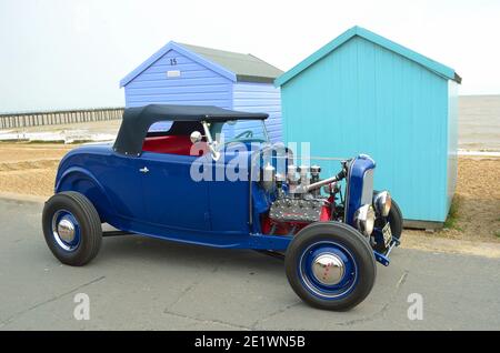 Classic Blue Hot Rod vor Strandhütten an der Strandpromenade geparkt. Stockfoto