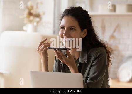 Glückliche junge Frau nehmen Sprachnachricht auf dem Handy auf Stockfoto