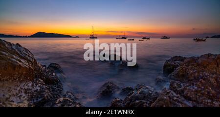 Langzeitbelichtung Bild der dramatischen Himmel Seestück mit Felsen in Der Vordergrund Sonnenuntergang oder Sonnenaufgang Landschaft Hintergrund schönes Licht Natur erstaunliche Länder Stockfoto