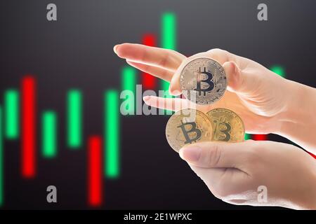 Hand halten Splitter Bitcoins und New Virtual Money Konzept und Konzept für das finanzielle Wachstum im Hintergrund der Grafik Stockfoto