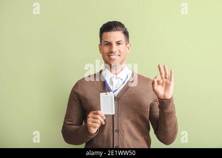 Junger Mann mit leerem Abzeichen auf farbigem Hintergrund Stockfoto