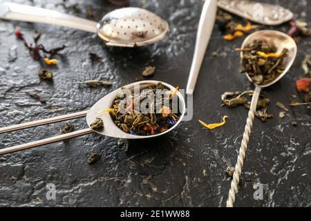 Sieb mit trockenem grünem Tee auf dunklem Hintergrund Stockfoto