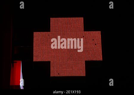 Leuchtendes Pixelkreuz von LED-Lampen auf schwarzem Hintergrund. Rotes Kreuz Symbol für Gesundheit, Medizin, Selbstversorgung. Stock Foto mit leerem Platz für Text und Design Stockfoto