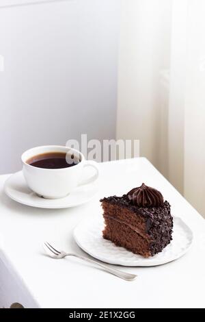Schokoladenkuchen und Kaffee, Stillleben in einem hellen Innenraum. Stockfoto