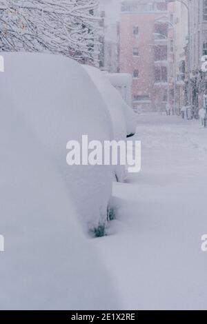 Mehrere Autos auf der Straße in Madrid mit Schnee bedeckt. Mehr als 30 cm Schnee. Filomena Storm. Stockfoto