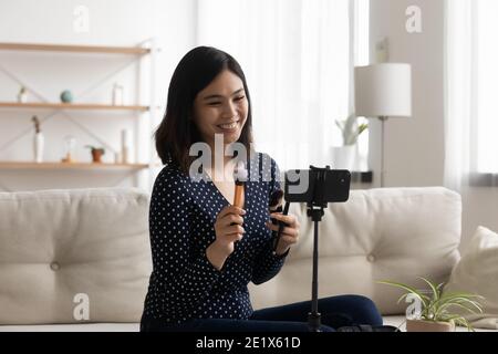 Glücklich junge koreanische Influencer Aufnahme pädagogische Make-up-Video. Stockfoto