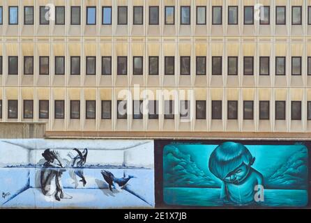 Kunstwerk am Flussufer in Malaga Spanien mit Bürogebäude im Hintergrund. Stockfoto