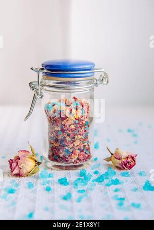 Hausgemachte trockene Rosenblüten Blumenbad Salzmischung für Aromatherapie und Entspannung in Badewanne, Bad Mischung. Innen kleine niedliche Glas. Badesalz mit Kraut gemischt Stockfoto