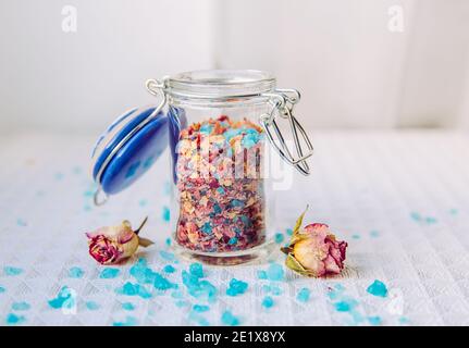 Hausgemachte trockene Rosenblüten Blumenbad Salzmischung für Aromatherapie und Entspannung in Badewanne, Bad Mischung. Innen kleine niedliche Glas. Badesalz mit Kraut gemischt Stockfoto