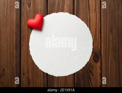 Draufsicht Valentinstag Hintergrund mit rotem Herz und weiß Handgefertigte Grußkarte Mockup auf einem Vintage-Holztisch Stockfoto