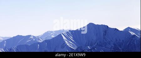 Panoramablick auf hohe Schneeberge im Dunst. Winterberge am frühen Morgen. Georgien, Region Gudauri. Kaukasus. Stockfoto