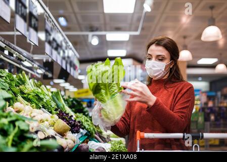 Schöne Frau trägt schützende Einweg-Maske Shopping in Mall. Neues normales Konzept während der Pandemiekorona,covid19. Stockfoto