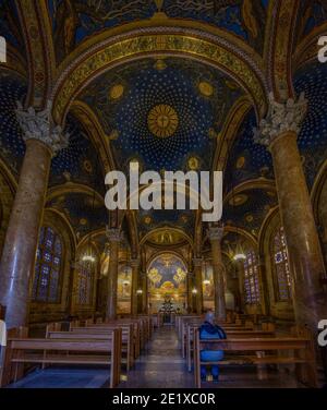 Jerusalem, Israel - 17. Dezember 2020: Ein einziger Besucher genießt das geschmückte Innere der Kirche aller Völker in Gethsemane, Jerusalem, Israel Stockfoto