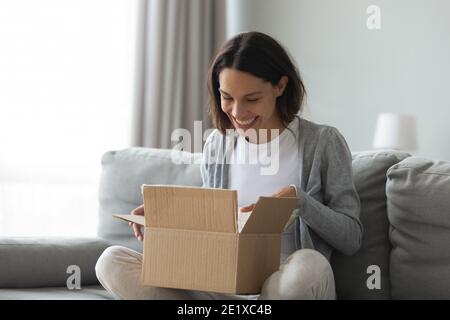 Nahaufnahme überglücklich Frau öffnen Karton mit Paket Stockfoto