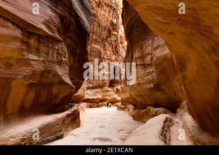 (Selektiver Fokus) atemberaubende Aussicht auf eine Person in der Ferne zu Fuß auf dem Weg, der zu Al Khazneh (Schatzkammer). Stockfoto