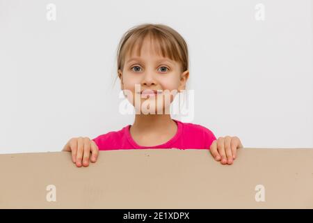 Nettes kleines Mädchen, das in einem großen Karton steht und Verstecken spielen möchte Stockfoto