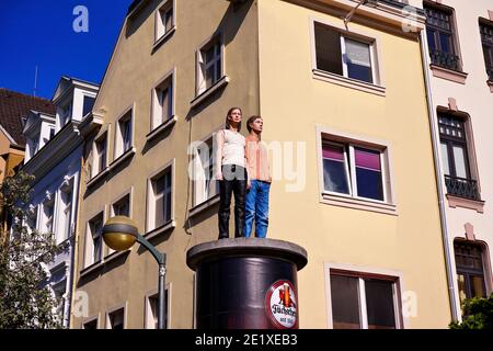 Sogenannte "Säulenheilige" (lebensechte Skulpturen auf Werbungssäulen). Künstler: Christoph Pöggeler. Lage: Düsseldorf, Burgplatz, Altstadt. Stockfoto