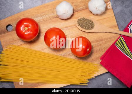 Zutaten Tomaten, Basilikum, Knoblauch, Spaghetti für italienische Gerichte auf Holzbrett Stockfoto