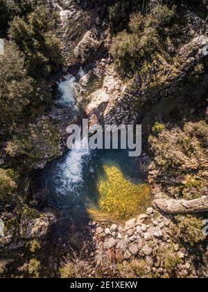 Luftaufnahme eines Gebirgsbaches, der in eine klare stürzt Pool in Pirio auf Korsika Stockfoto